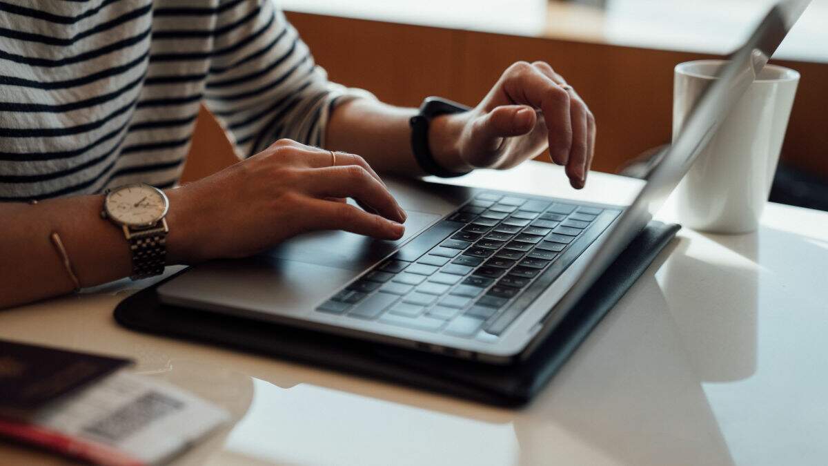 Pessoa utilizando laptop em cima de uma mesa